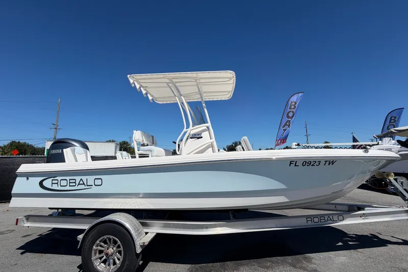 Slide: The Image of 2024 Robalo 206 Cayman boat on trailer, displayed outdoors under clear blue sky. - 1