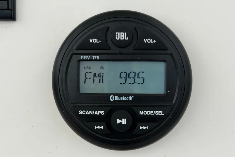 Slide: The Image of JBL PRV-175 radio display on 2024 Robalo 206 Cayman, showing FM 99.5 frequency. - 18