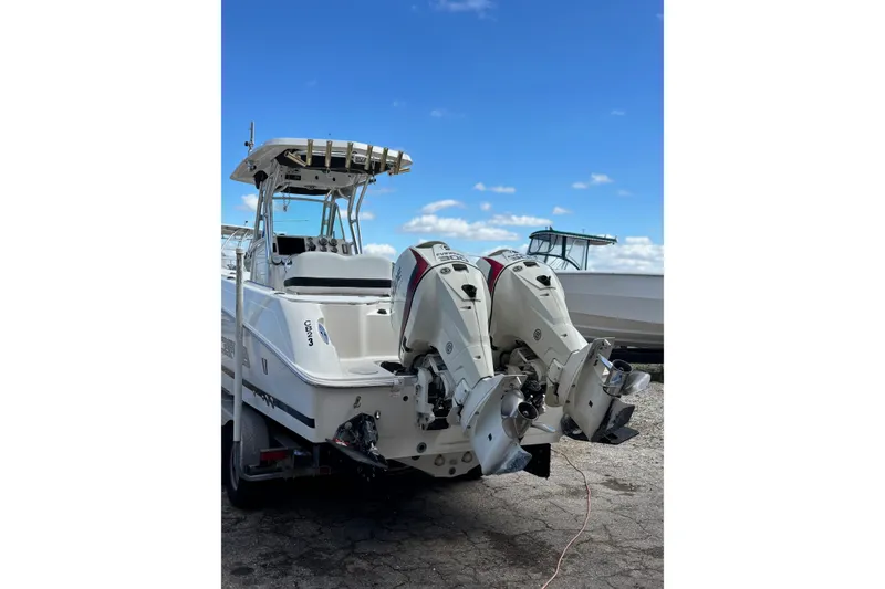 Slide: The Image of 2013 Wellcraft 30 Scarab Sport boat with dual outboard engines, parked on a sunny day. - 5