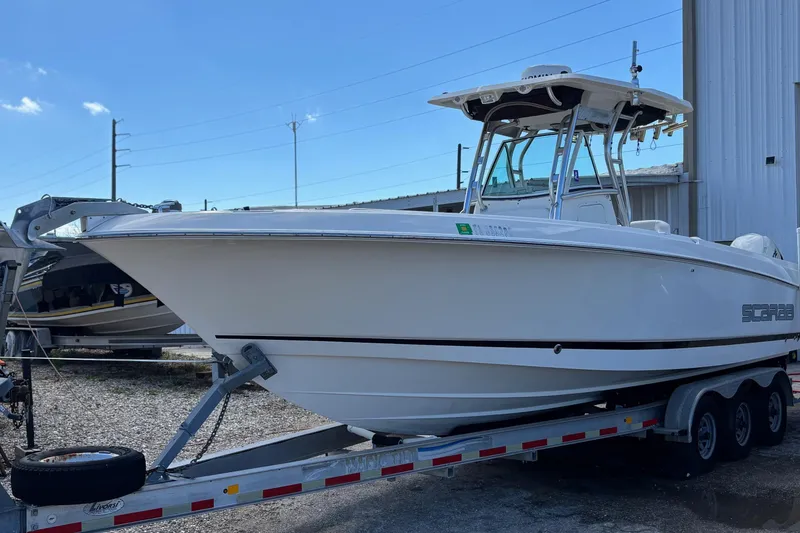 Slide: The Image of 2013 Wellcraft 30 Scarab Sport boat on trailer, parked outdoors. - 1