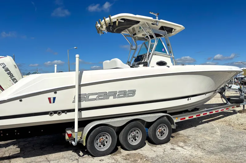 Slide: The Image of 2013 Wellcraft 30 Scarab Sport boat on trailer under clear blue sky. - 20