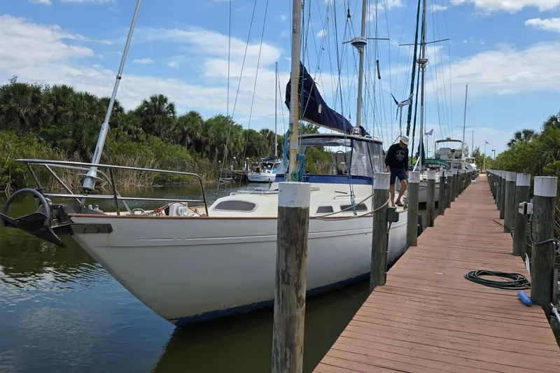 The Image of 1977 Camper & Nicholsons 42 Ketch docked at a marina with lush greenery. - 0