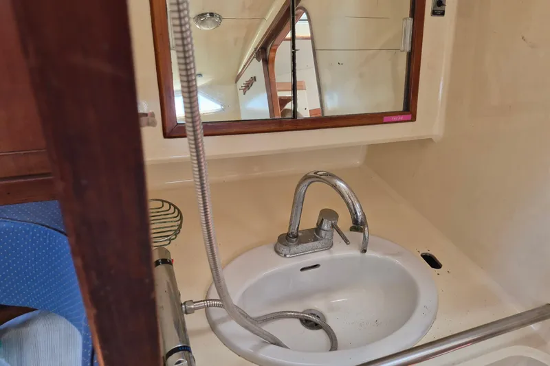 Slide: The Image of Interior of 1977 Camper & Nicholsons 42 Ketch, featuring a compact bathroom sink and mirror. - 16