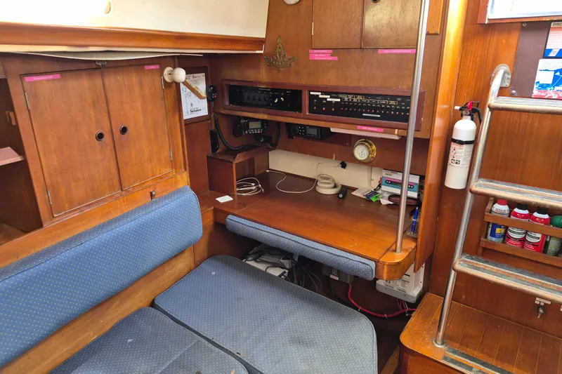Slide: The Image of Interior of a 1977 Camper & Nicholsons 42 Ketch, featuring a navigation station and seating area. - 19
