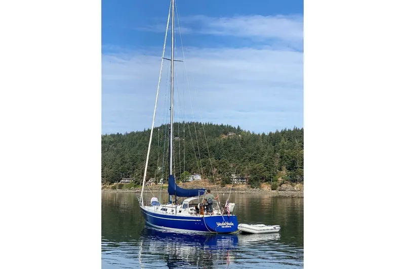 Slide: The Image of 1981 Nordic Boats 40 sailboat on calm water with forested shoreline background. - 67