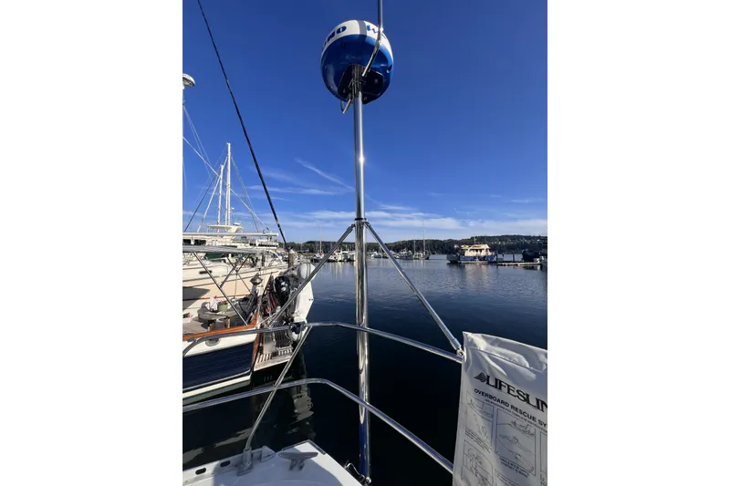 Slide: The Image of 1981 Nordic Boats 40 at marina, clear sky, calm water, Lifesling visible. - 29