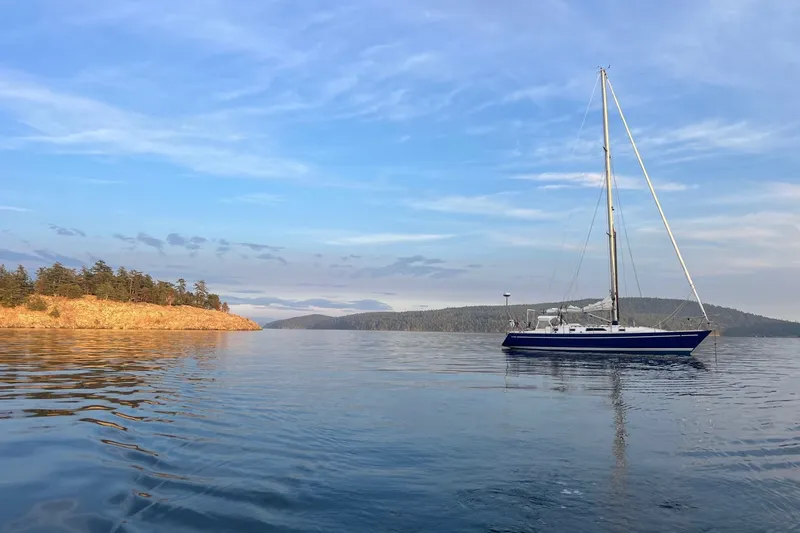 Slide: The Image of 1981 Nordic Boats 40 sailboat on calm water with scenic coastal backdrop. - 68