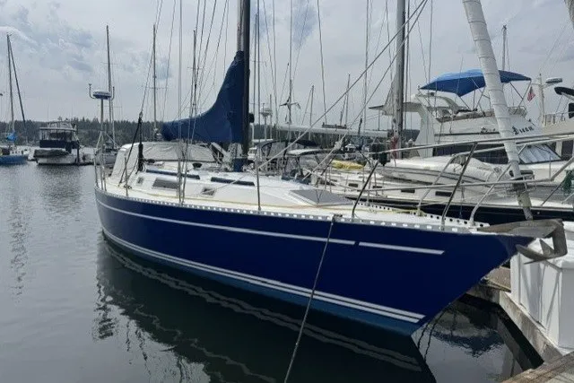 Slide: The Image of 1981 Nordic Boats 40 sailboat docked in a marina, featuring a sleek blue hull. - 0