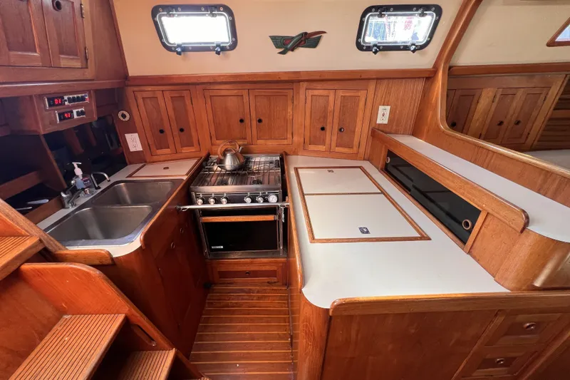 Slide: The Image of 1981 Nordic Boats 40 interior kitchen with wooden cabinetry, stove, and dual sink. - 46