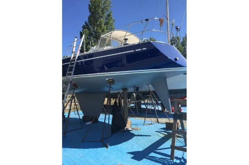 Slide: The Image of 1981 Nordic Boats 40 sailboat on dry dock with blue hull and ladder. - 65