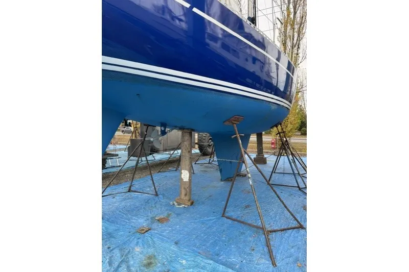 Slide: The Image of 1981 Nordic Boats 40 sailboat on stands, blue hull, outdoor setting. - 64