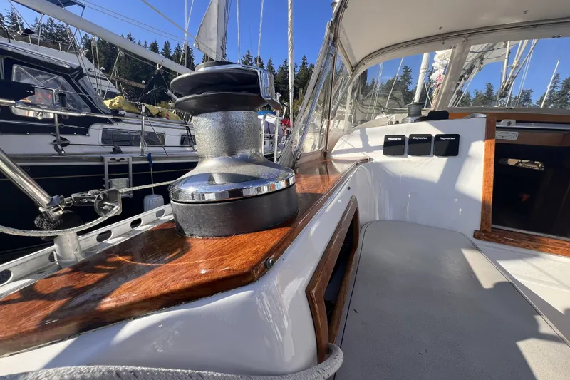 Slide: The Image of 1981 Nordic Boats 40 sailboat cockpit with winch, wood trim, and marina view. - 20