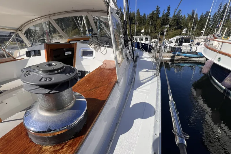 Slide: The Image of 1981 Nordic Boats 40 sailboat docked, showcasing deck and winch in a marina setting. - 21