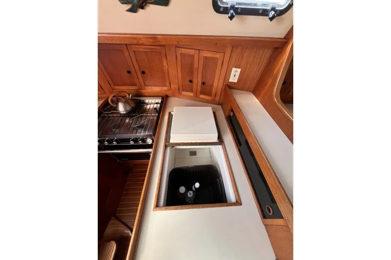 Slide: The Image of 1981 Nordic Boats 40 interior kitchen with stove, wooden cabinets, and built-in cooler. - 48