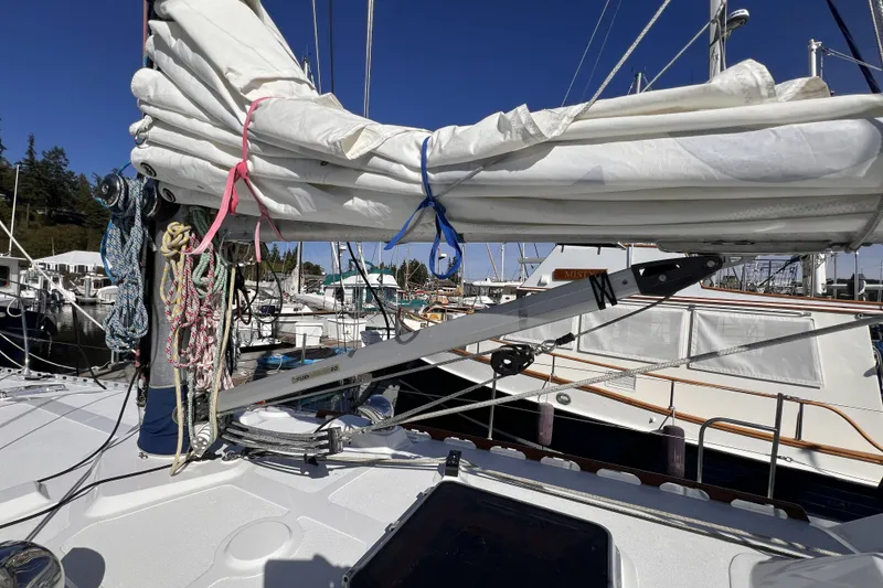 Slide: The Image of 1981 Nordic Boats 40 sailboat with neatly tied sails and colorful ropes at a marina. - 11