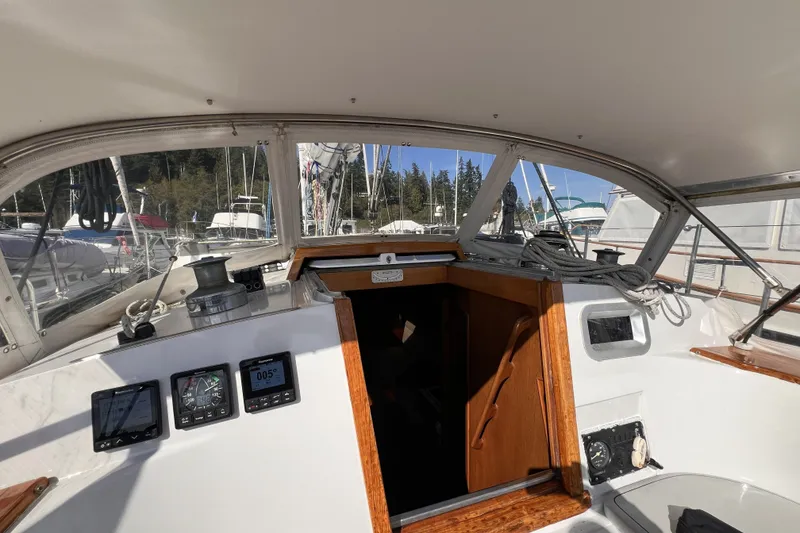 Slide: The Image of Cockpit view of 1981 Nordic Boats 40 sailboat with navigation instruments and marina background. - 25