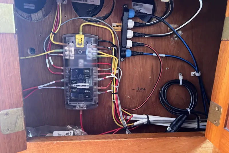 Slide: The Image of Electrical panel inside a 1981 Nordic Boats 40, showcasing wiring and circuit breakers. - 57