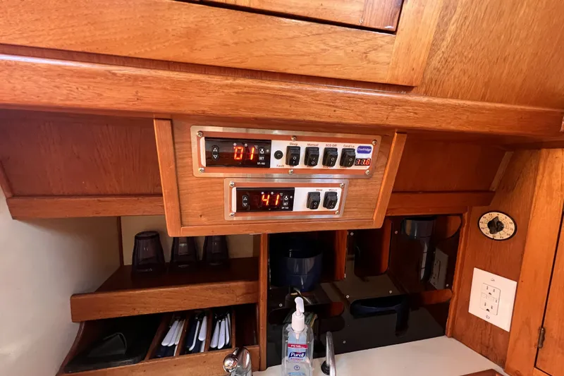 Slide: The Image of Control panel in 1981 Nordic Boats 40 cabin with wooden cabinetry and storage compartments. - 50