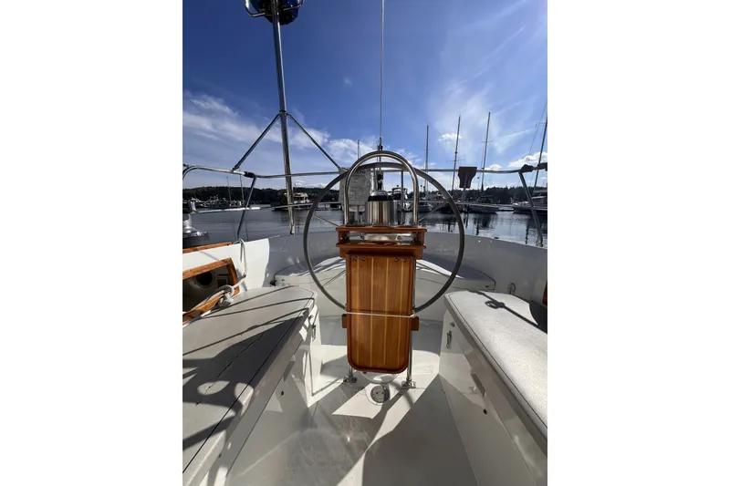 Slide: The Image of Cockpit view of 1981 Nordic Boats 40 sailboat with steering wheel and marina backdrop. - 26