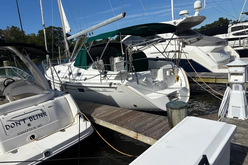 Slide: The Image of 1999 Beneteau Oceanis 381 sailboat docked at marina with green canopy. - 1