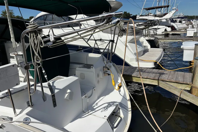 Slide: The Image of 1999 Beneteau 381 sailboat docked at marina, featuring ropes and deck details. - 2