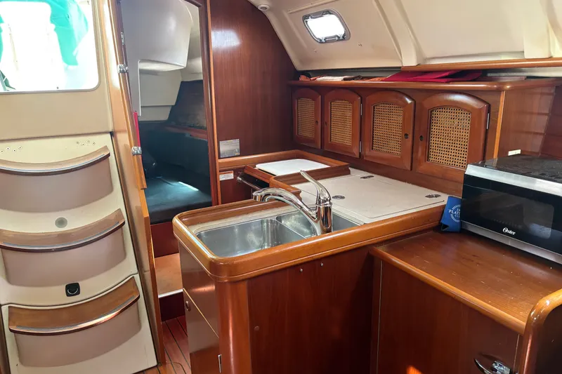 Slide: The Image of Interior of 1999 Beneteau 381 sailboat featuring kitchen area with sink and cabinets. - 10