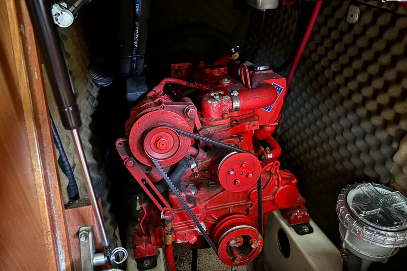 Slide: The Image of Red engine inside a 1999 Beneteau 381 sailboat, surrounded by soundproofing material. - 23