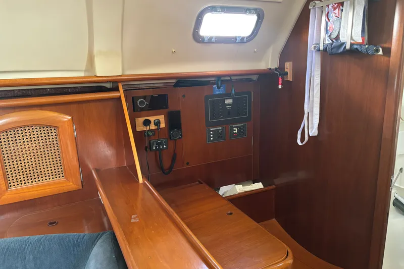 Slide: The Image of Interior of a 1999 Beneteau 381 sailboat with wooden cabinetry and control panel. - 11