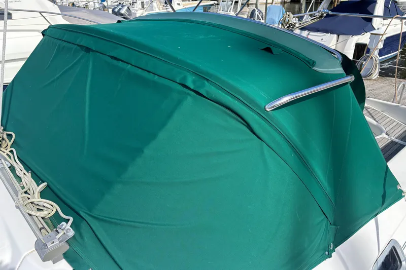 Slide: The Image of Green canvas cover on a 1999 Beneteau 381 sailboat, docked at a marina. - 9