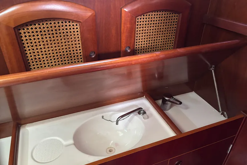 Slide: The Image of Wooden interior of 1999 Beneteau 381 yacht with sink and storage cabinets. - 21
