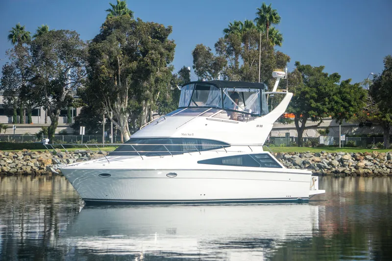The Image of 2006 Carver 33 Super Sport yacht on calm water, surrounded by trees. - 0