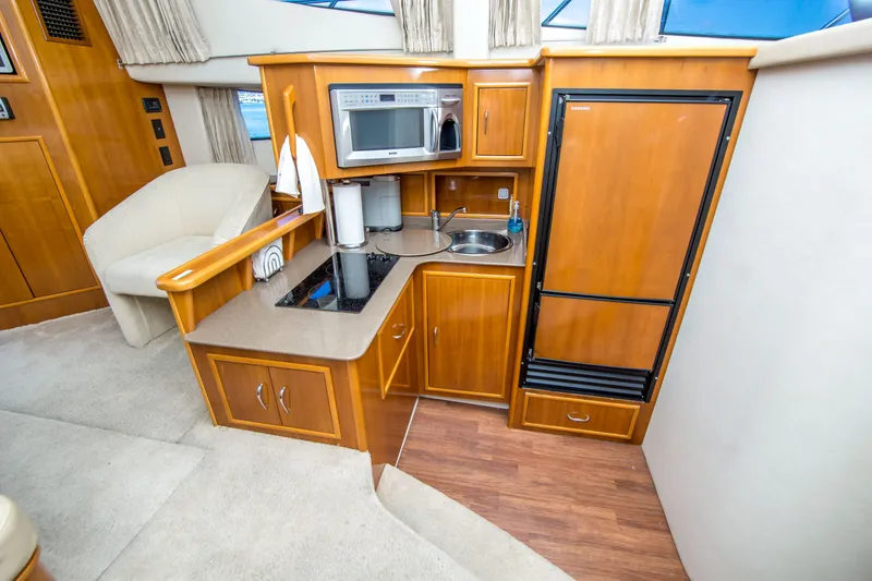 Slide: The Image of Interior of 2006 Carver 33 Super Sport yacht kitchen with wood cabinetry and appliances. - 25