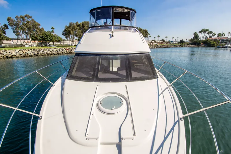 Slide: The Image of 2006 Carver 33 Super Sport yacht on calm water, surrounded by trees and clear skies. - 13