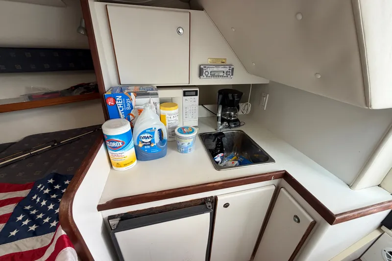 Slide: The Image of 2001 Tiara Yachts 2900 Coronet interior with kitchenette, cleaning supplies, and American flag. - 14