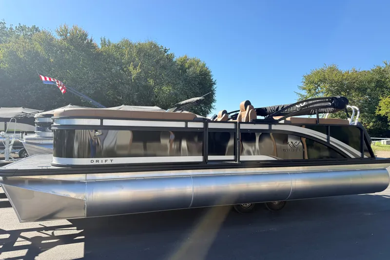 Slide: The Image of 2027 Whisper Drift RLS pontoon boat with sleek design, parked outdoors. - 3