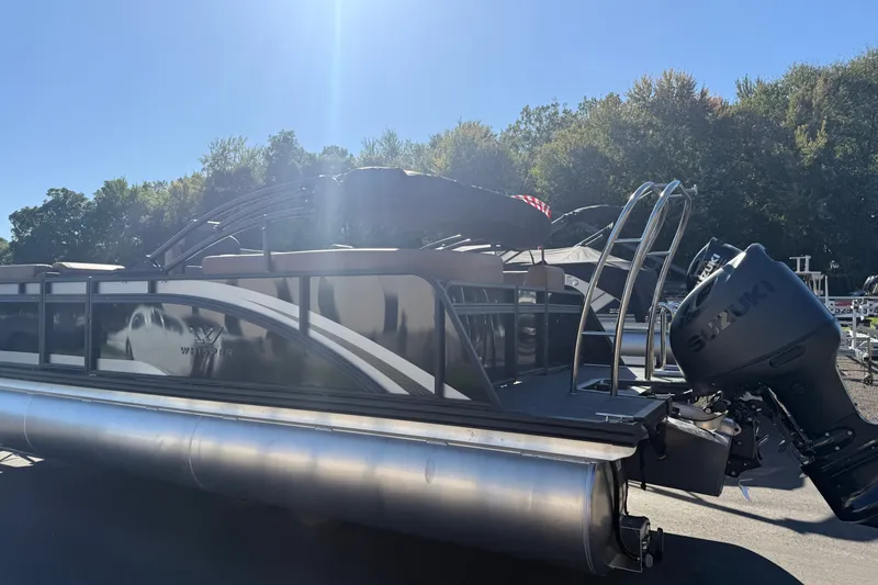 Slide: The Image of 2027 Whisper Drift RLS pontoon boat with Suzuki outboard motor under clear blue sky. - 4