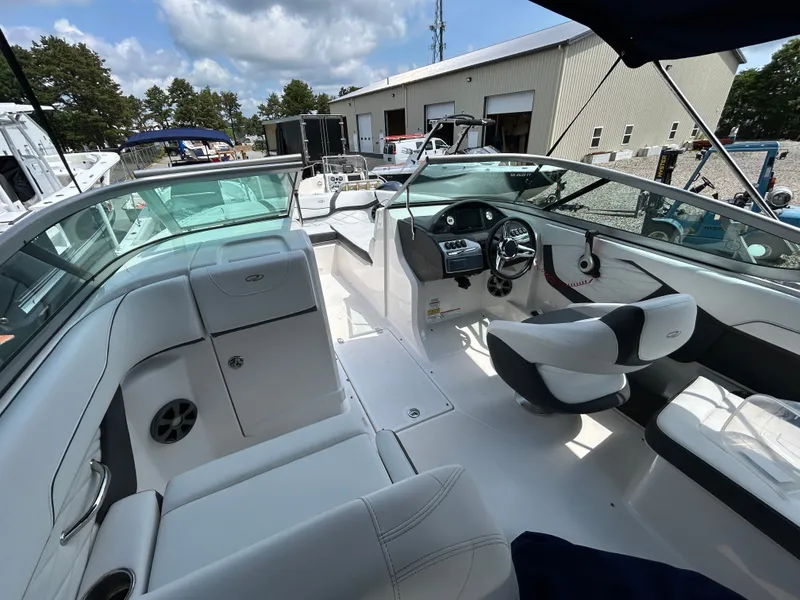 Slide: The Image of The image shows the cockpit of a 2018 Regal 23 OBX boat with white seating and a modern helm. - 14