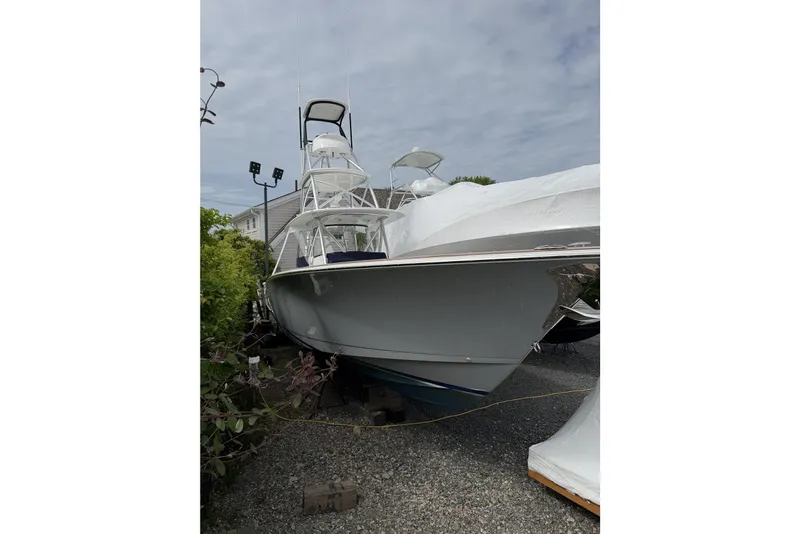 Slide: The Image of 2022 Valhalla Boatworks V-41, sleek design, parked outdoors on gravel. - 12