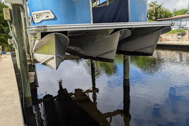 Slide: The Image of 2019 Avalon 2485LSZ pontoon boat lifted above water, dockside view. - 1