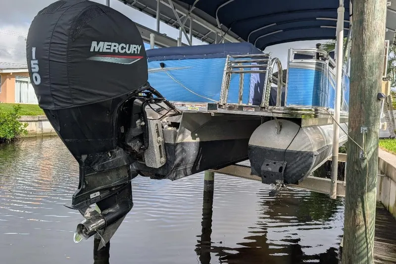 Slide: The Image of 2019 Avalon 2485LSZ pontoon boat with Mercury 150 outboard motor on a lift. - 15