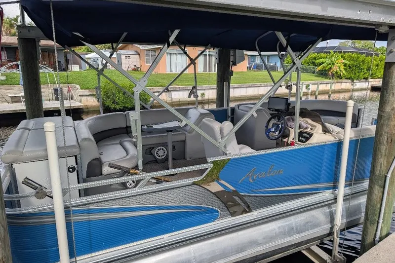 Slide: The Image of 2019 Avalon 2485LSZ pontoon boat docked, featuring blue exterior and spacious seating. - 3