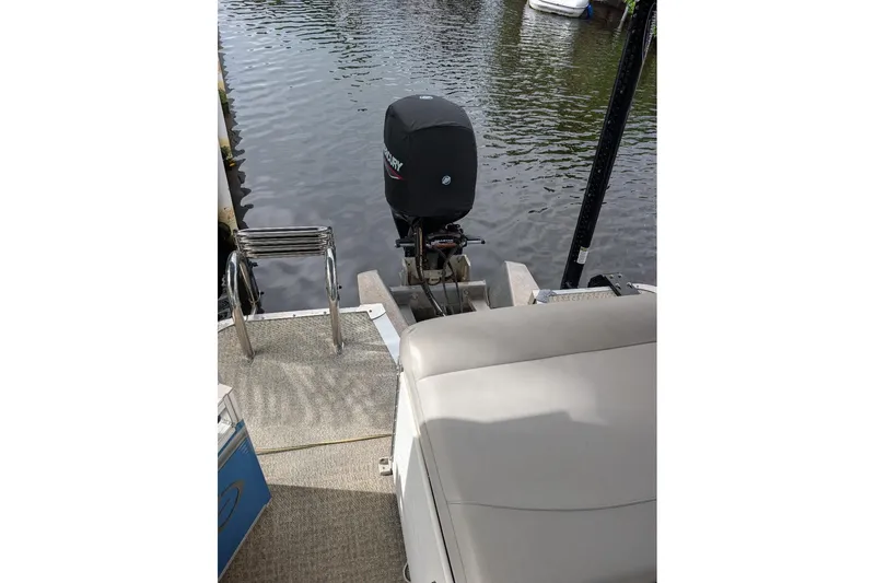 Slide: The Image of 2019 Avalon 2485LSZ pontoon boat with Mercury outboard motor on a calm waterway. - 14