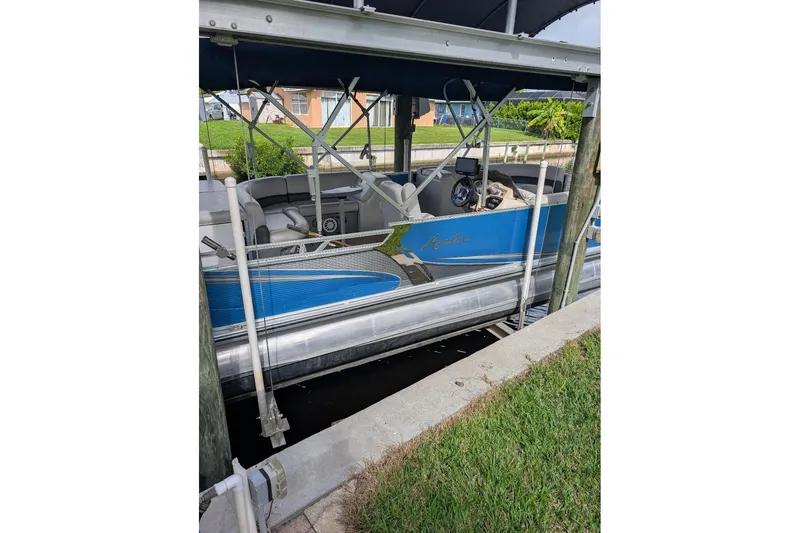 Slide: The Image of 2019 Avalon 2485LSZ pontoon boat docked under a canopy. - 5