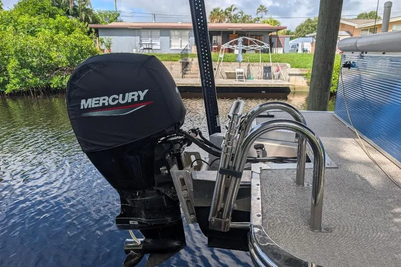Slide: The Image of 2019 Avalon 2485LSZ boat with Mercury outboard motor docked by a canal. - 13
