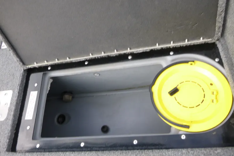 Slide: The Image of 2023 Tracker Targa V-19 Combo storage compartment with yellow lid. - 16