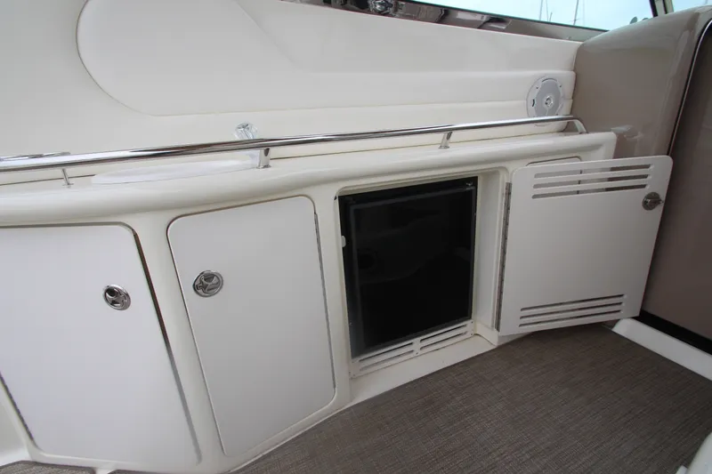 Slide: The Image of 2001 Sea Ray 380 Sundancer interior with open storage compartments and mini fridge. - 21