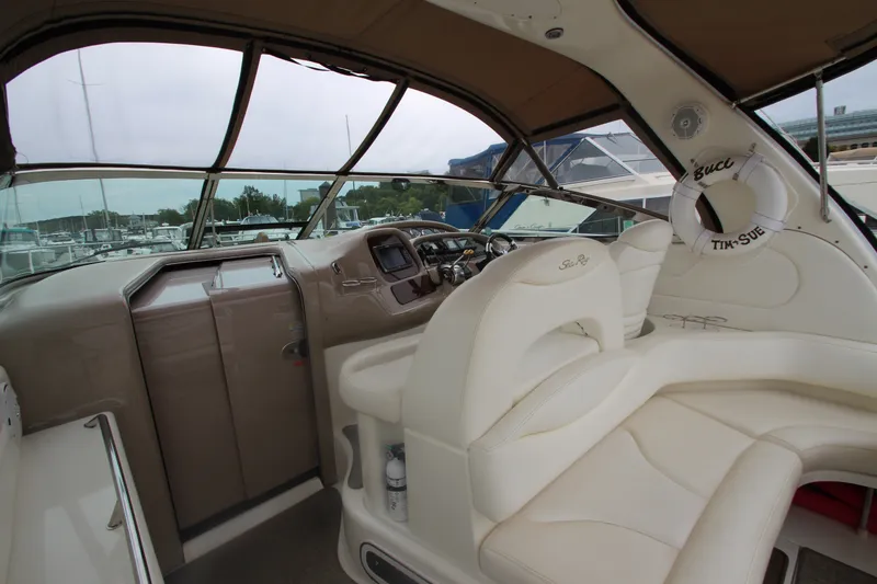 Slide: The Image of 2001 Sea Ray 380 Sundancer cockpit with beige seating and helm, docked at marina. - 17