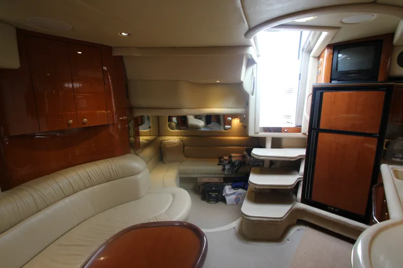 Slide: The Image of Luxurious interior of a 2001 Sea Ray 380 Sundancer yacht with plush seating and wooden cabinetry. - 46