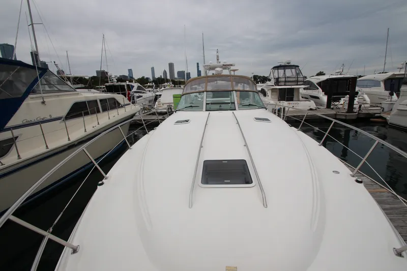 Slide: The Image of 2001 Sea Ray 380 Sundancer yacht docked at marina with city skyline in background. - 14