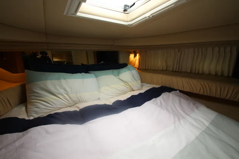 Slide: The Image of Cozy cabin interior of 2001 Sea Ray 380 Sundancer with skylight and plush bedding. - 36
